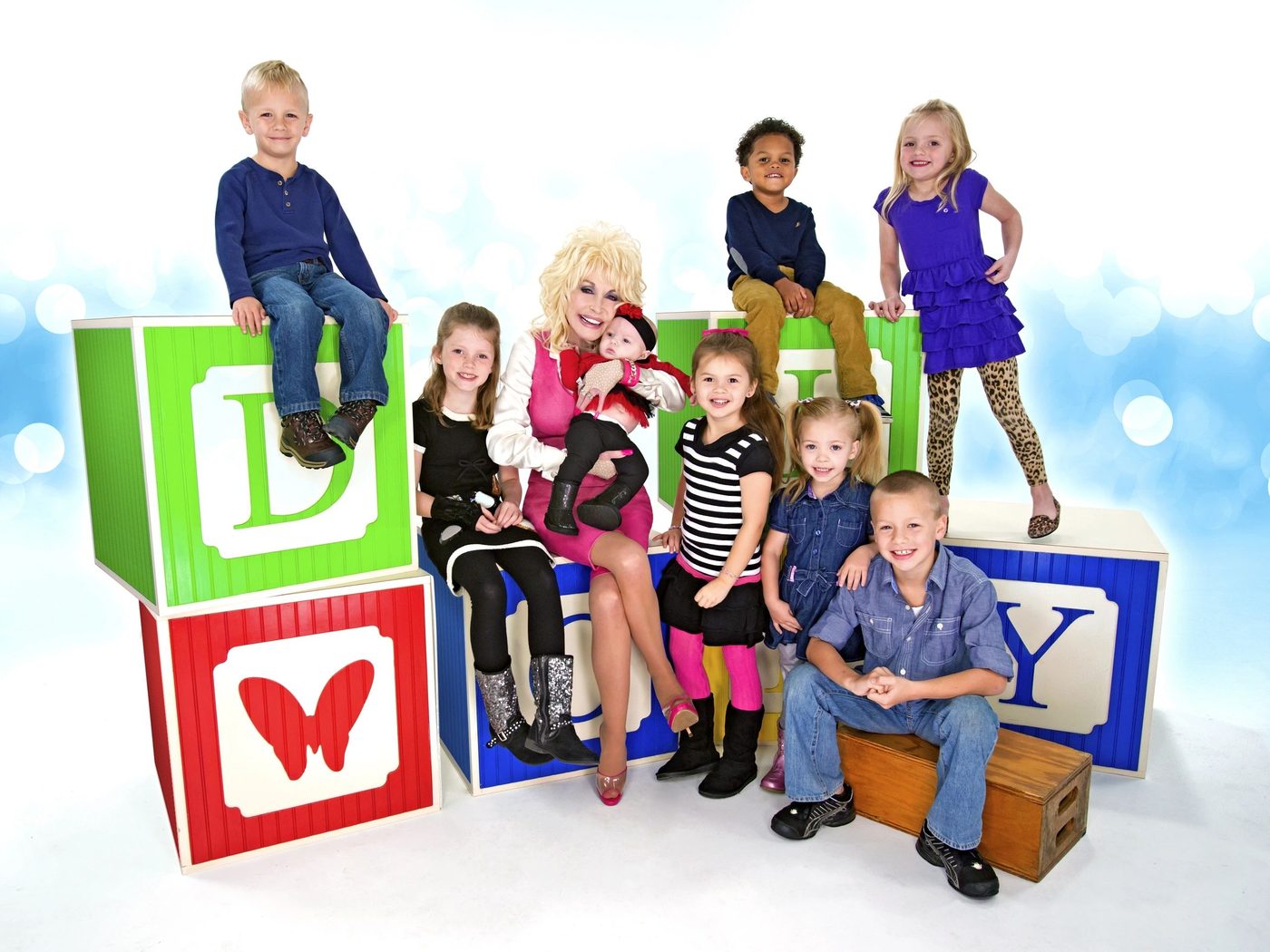 Dolly Parton smiling with a group of young children